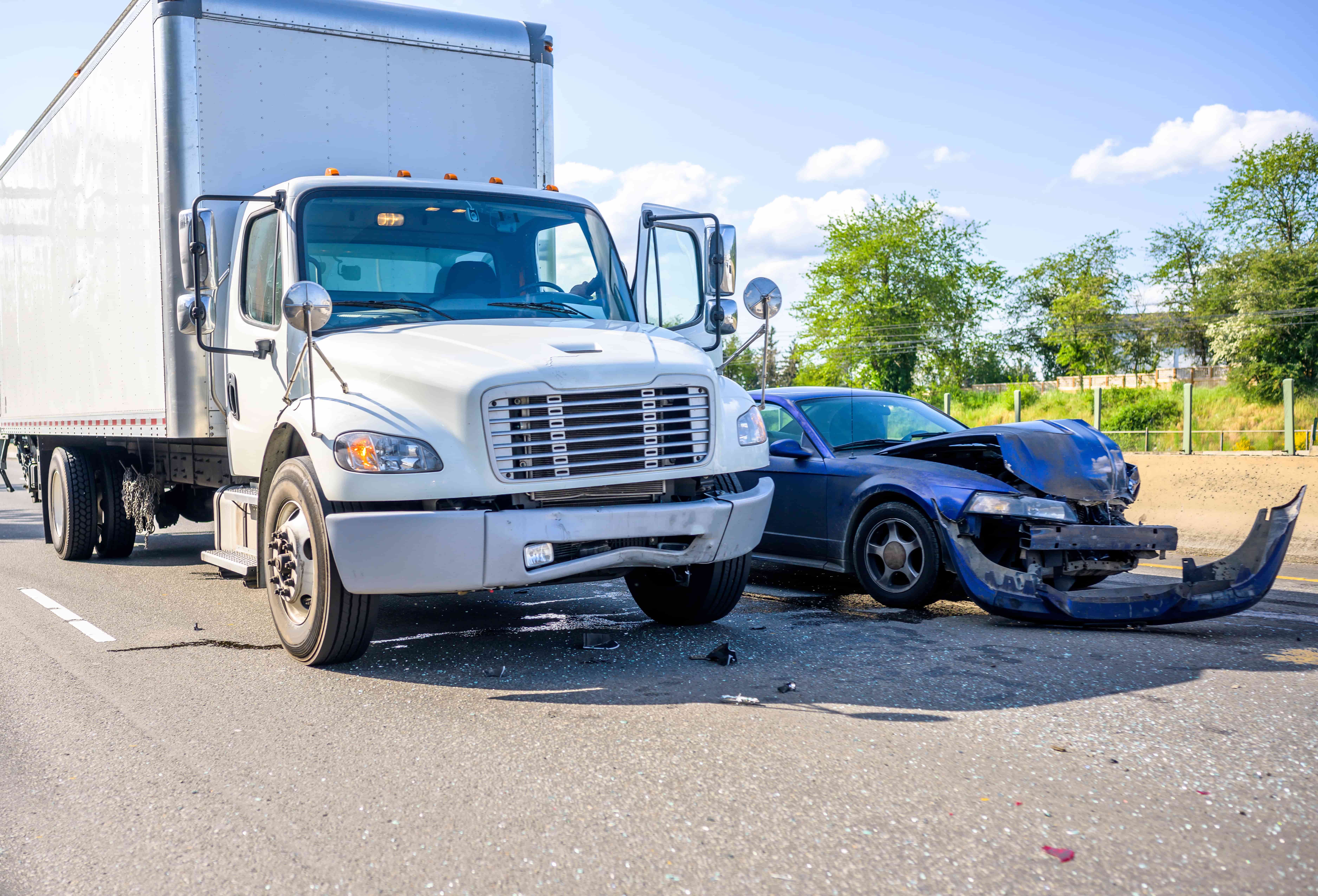 Semi-truck and car collision on roadway showing serious commercial truck accident scene.